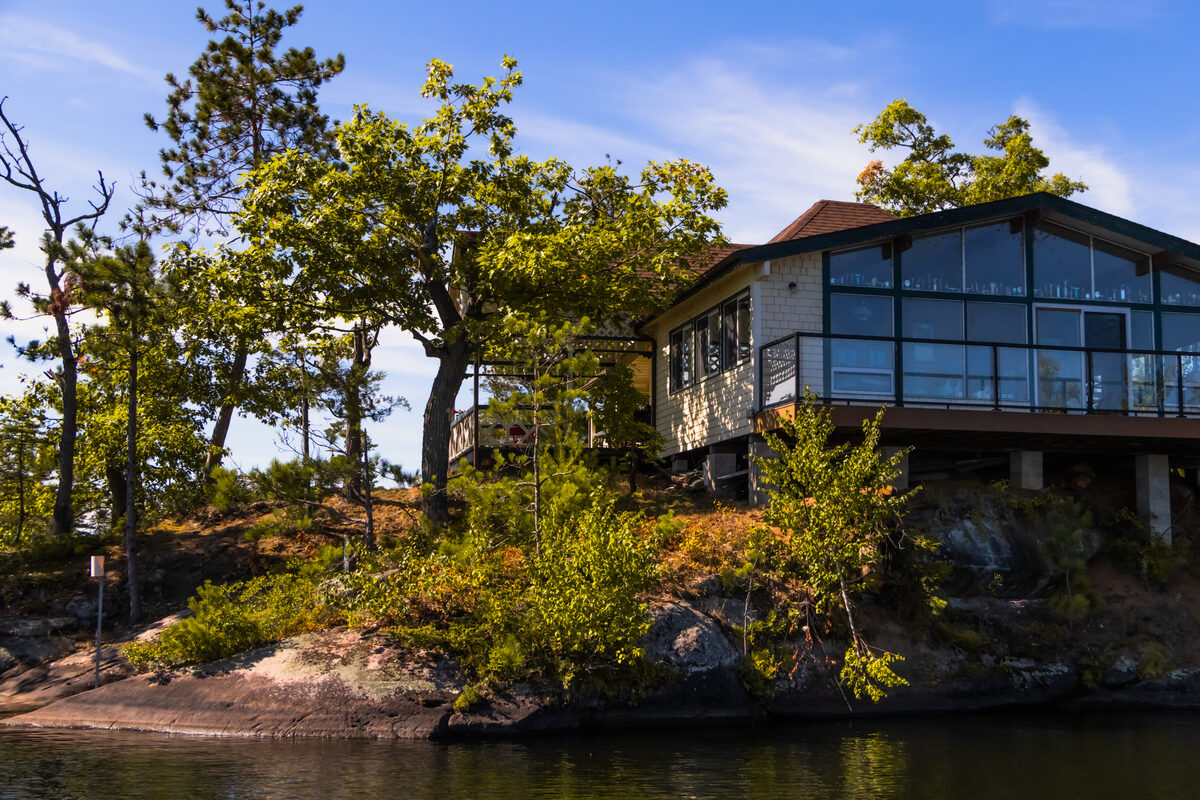 A boathouse and accessory structures along a wooded shoreline